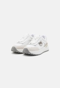 Fehér sneaker, hálós és velúr anyagból, vastag fehér talppal és ezüst színű kiegészítőkkel. Fűzőkkel rendelkezik, és sportos megjelenésű.