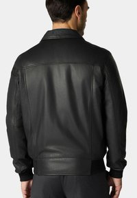 Černá kožená bunda s hladkou texturou, klasickým límcem, pružnými manžetami a lemem. Obsahuje čisté linie a minimalistický design.