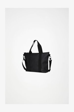 Melnā somiņa ar izturīgu materiālu, tai ir teksturētas sānu siksnas, rāvējslēdzēja aizdare un regulējams plecu siksna.