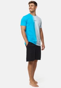 Camiseta de gradient de azul claro a gris con mangas cortas y cuello redondo, combinada con pantalones cortos negros. Sin patrones ni adornos visibles.