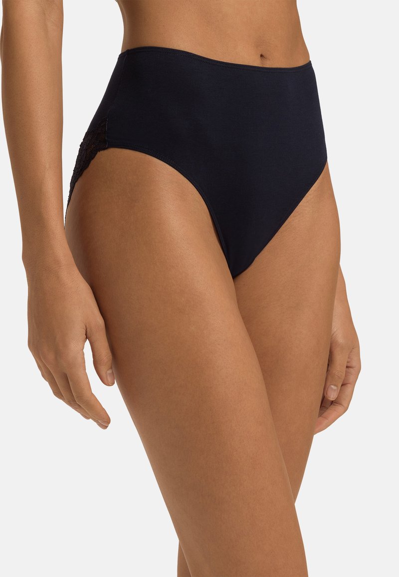 Höga svarta trosor med en slät tyg och spetsdetaljer på sidorna, med en klassisk design och mjuk textur.