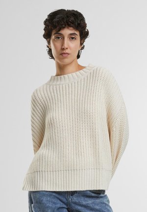 Maglione oversize beige chiaro in maglia con scollatura ampia a costine e motivo testurizzato. L'orlo inferiore ha una finitura a costine. Abbina a un paio di jeans in denim.