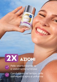 Lozione Nivea Luminous Skin Glow in bottiglia trasparente con tappo argento; presenta un'etichetta viola con testo che ne evidenzia i benefici.