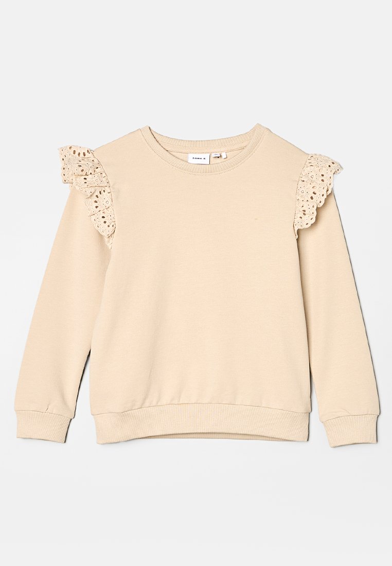 Pull beige avec bordure en dentelle sur les épaules, décolleté arrondi, manches longues et ourlet côtelé. Matière douce en mélange de coton.