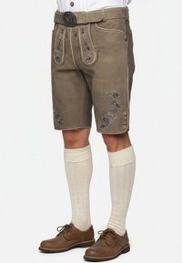 Men's lederhosen, gray leather, embroidered floral details, side buttons, paired with cream knee-high socks and brown shoes.