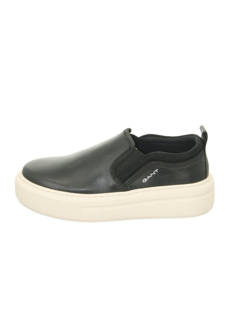 Black leather slip-on shoe with a white rubber sole. Features an elastic side panel and logo detail on the heel. Smooth texture throughout.