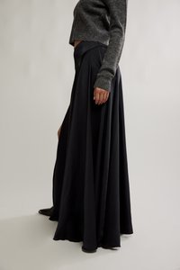 Maxiskjørt i svart stoff, med et flytende design, høy midje og jevn tekstur, som elegant faller ned til gulvet.