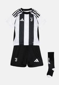 Equipación juvenil de fútbol en blanco y negro que incluye una camiseta a rayas, pantalones cortos negros y calcetas negras a juego con el logo. Fabricada con tejido transpirable.
