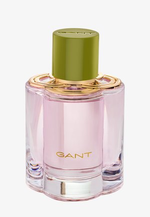 GANT perfume bottle, light pink liquid in clear glass with gold accents, topped with an olive green cap.