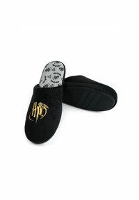 Black slip-on slippers made of soft fabric, featuring a gold embroidered logo and a patterned gray insole. The sole includes horizontal stripes.