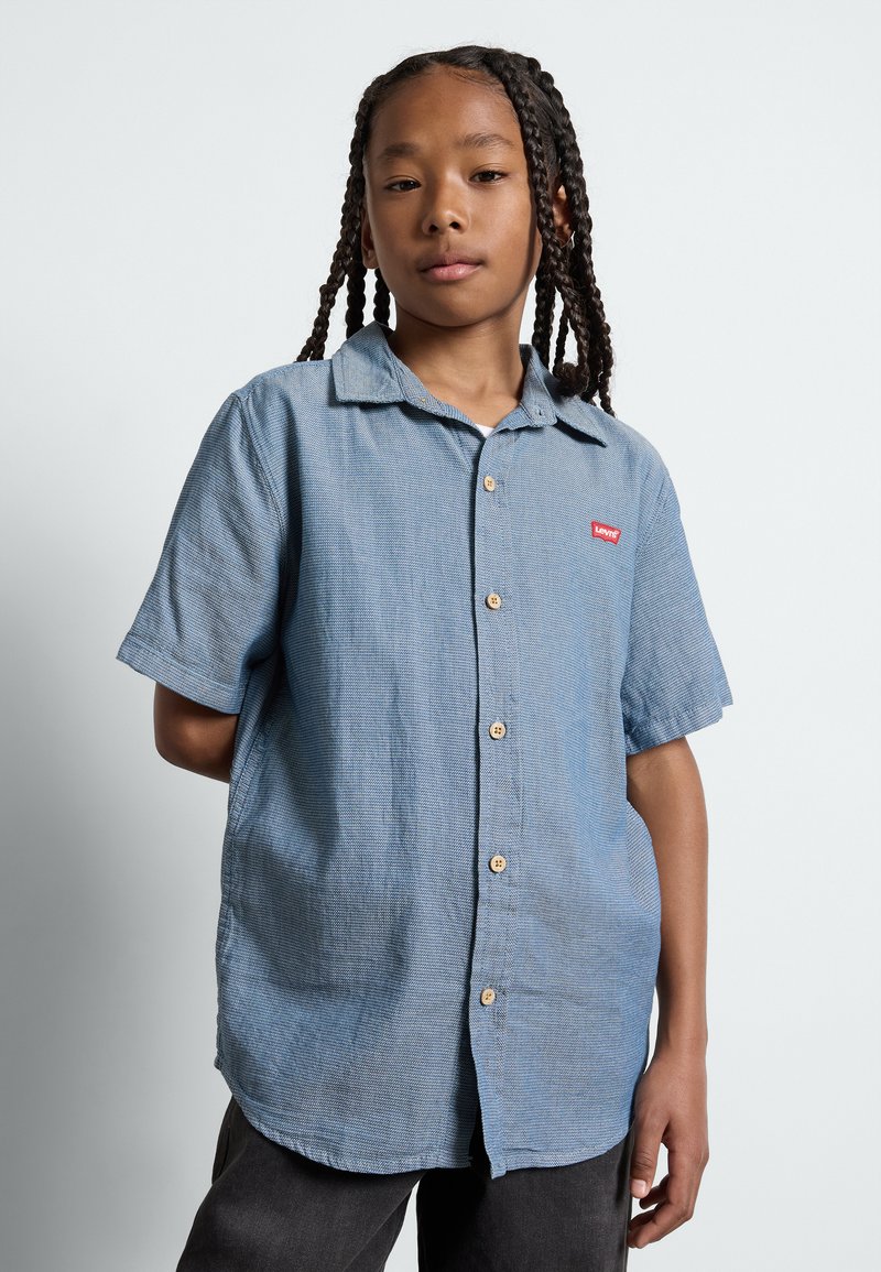 Korte mouwen blauwe overhemden met een textuur, voorzien van een rood Levi's logo, houten knopen en een klassieke kraag.