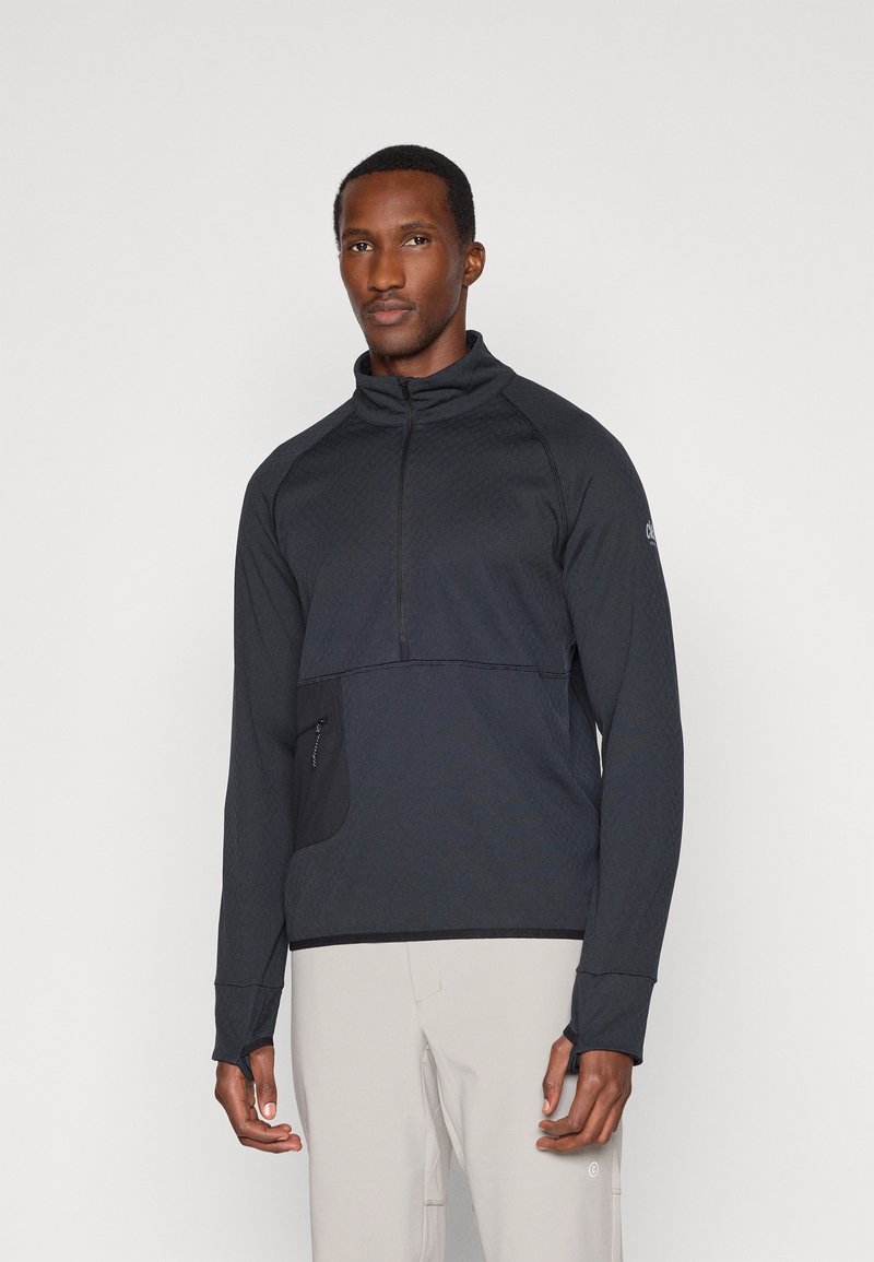 Veste pullover noire à zip quart en tissu texturé, col haut, manches longues et poche avant en biais. Design simple et moderne.