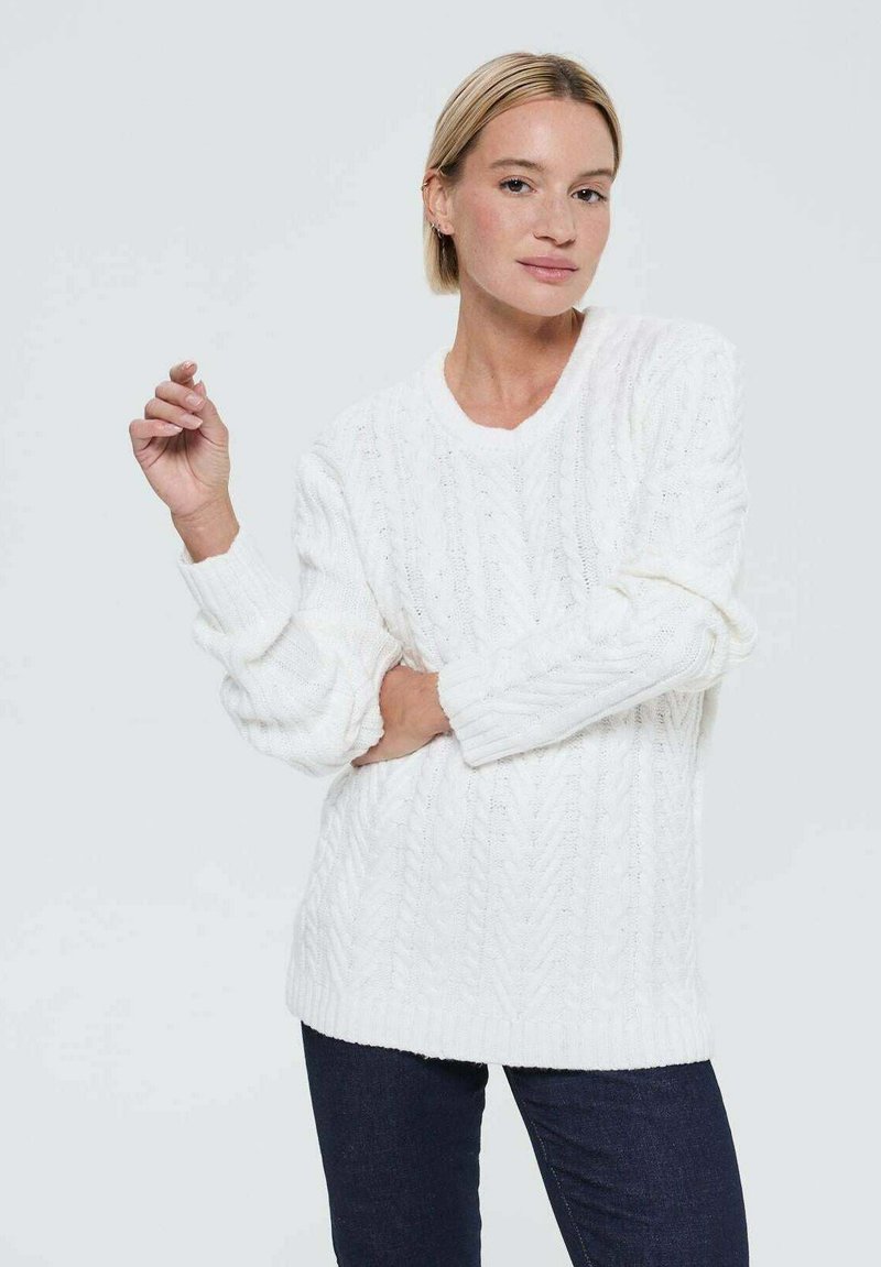 Pull en tricot blanc avec une coupe ample, doté d'un col rond et de manches longues. Texture douce et motifs légèrement en relief sur l'ensemble.