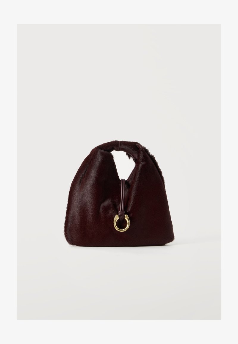Sac à main en fourrure douce marron foncé avec une poignée arrondie et un détail d'anneau circulaire doré au centre avant.