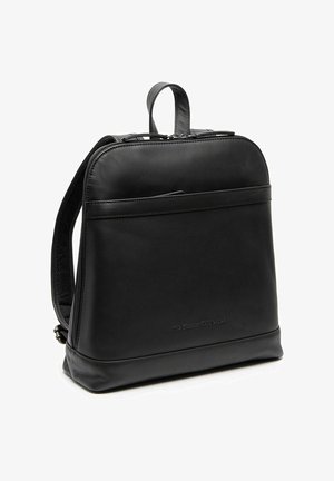 Sac à dos en cuir noir avec poignée supérieure, bretelles rembourrées, poche zippée à l'avant et embossage discret de la marque sur fond blanc.