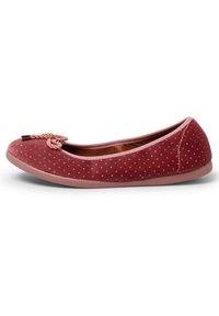 Ballerine in suede rosso con pois bianchi, caratterizzate da un accento in corda intrecciata sulla punta e una suola in gomma flessibile di colore chiaro.
