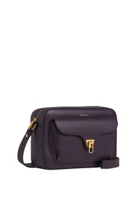 Borsa in pelle viola con chiusura e zip dorate. Presenta una tasca anteriore con pattina, tracolla regolabile e logo impresso sulla parte anteriore.