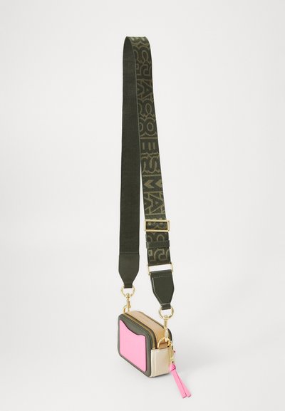 Colorful crossbody bag with pink and beige panels, gold hardware, detachable strap, and a textured green adjustable strap featuring logos.