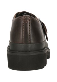 Brauner Lederschuh mit abgerundetem Rücken, strukturiertem schwarzen Gummisohle und kontrastierenden hellen Nähdetails. Keine sichtbaren Beschläge oder Muster.