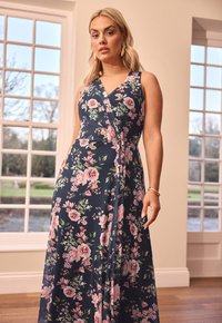 Kukkakuosiinen vyötärömekko tummansinisellä pohjalla, jossa on vaaleanpunaisia ja vihreitä kuvioita. Mekossa on V-pääntie ja se ulottuu lattiaan. Valmistettu sileästä, kevyestä kankaasta.