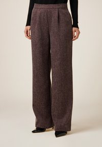 Spodnie o szerokich nogawkach z bordowego materiału o teksturowanym wykończeniu. Posiadają wysoki pas i przednie zakładki. W zestawieniu z czarnymi szpilkami o zaostrzonych noskach.