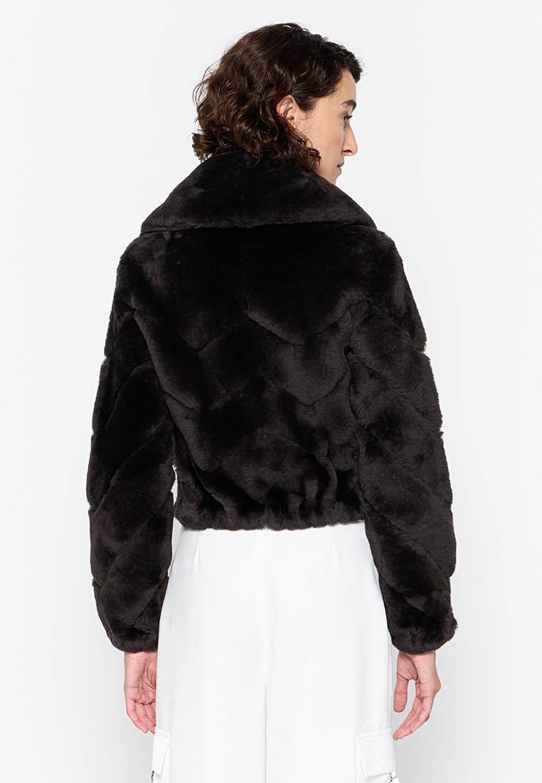 Schwarze Kunstpelzjacke mit einem cropped Design, ausgestattet mit einem breiten Kragen, gestepptem Muster und elastischem Saum. Die Rückansicht zeigt übergroße Ärmel.