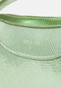 Groene leren tas met een glanzende textuur, voorzien van een slangenhuidpatroon en gouden branding aan de bovenkant. Glad, gebogen ontwerp.