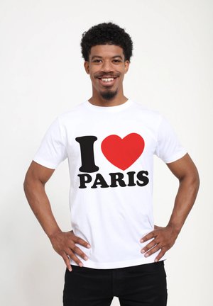 White t-shirt featuring a graphic print with "I" in black, a red heart, and "PARIS" in bold black letters. Short sleeves and crew neck.