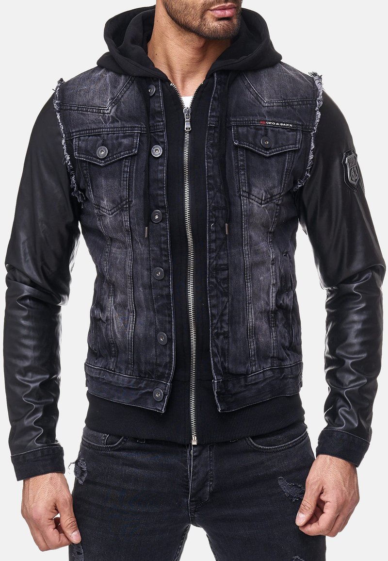 Jasje van denim en leer met een verwassen zwarte denim lijf, contrasterende zwarte leren mouwen, rits aan de voorkant en met knopen sluitende borstzakken.