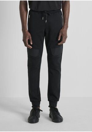 SLIM FIT IN INTERLOCK WITH FLAPS ON LEGS AND BACK PRINT - Trainingsbroek - black