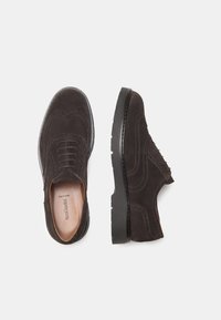 Scarpe in suede marrone con design a punta di ala, caratterizzate da dettagli brogue, punta rotonda e una spessa suola in gomma nera.