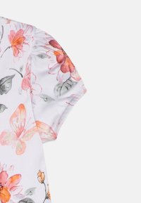 Kwiatowa bluzka z krótkim rękawem w białym kolorze, ozdobiona różowymi i pomarańczowymi kwiatami oraz motylami, z marszczeniem na ramieniu dla nadania tekstury.