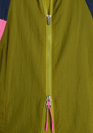 Grüne Jacke mit Reißverschluss, silbernem Zipper und pinkfarbenen Zugschnüren, zeigt strukturierten Stoff und Teile von dunklen und pinkfarbenen Ärmeln.