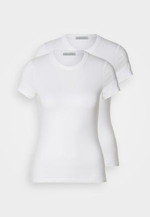 Two white cotton t-shirts with short sleeves, round necklines, and a fitted silhouette, displaying a smooth texture and minimalistic design.
