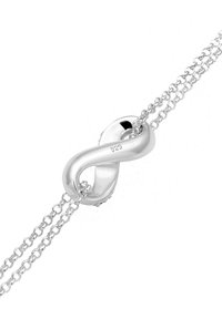 Armband i sterlingsilver med design av en oändlighetssymbol, med en slät yta och länkkedjeband. Märkt "925" för renhet.