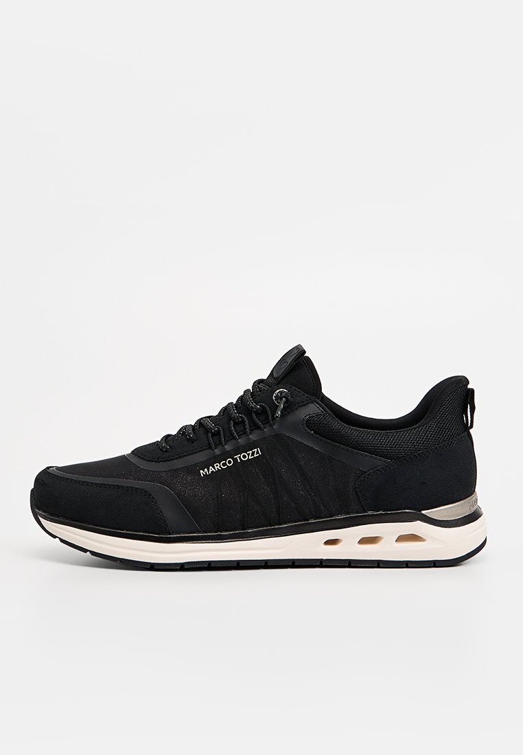 Chaussure de sport noire avec tige en maille et en daim, design à lacets, col rembourré, semelle blanche contrastante et détail logo sur le côté.