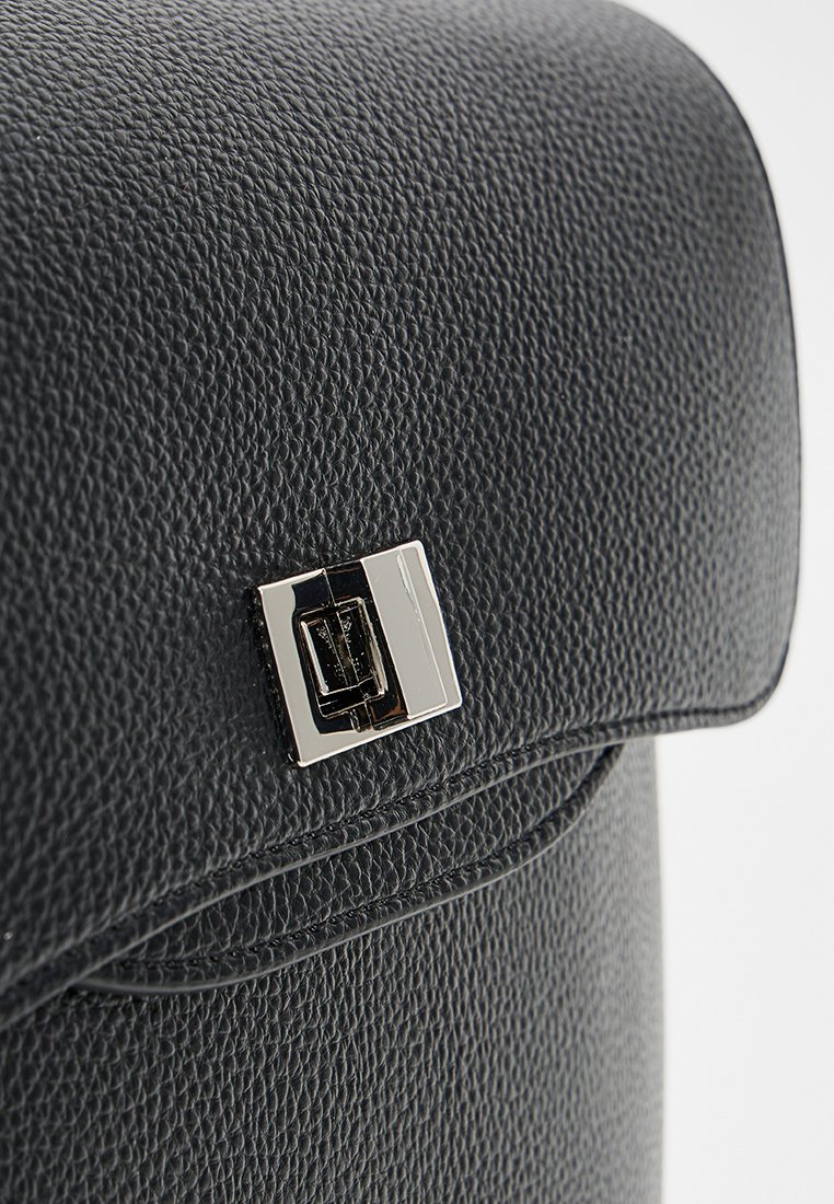 Schwarze strukturierte Lederhandtasche mit umgeschlagenem Deckel, ausgestattet mit einem silbernen rechteckigen Verschluss und genähten Details entlang der Kanten.