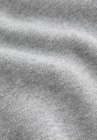Gray fabric with a soft, textured finish, showing a slight sheen and subtle pattern, possibly knit or woven, draped in gentle folds.