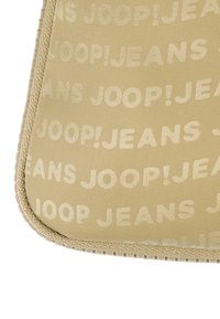 Busta in tessuto beige con un motivo in rilievo di "JOOP!JEANS" ripetuto più volte, con una superficie texturizzata e bordo cucito.