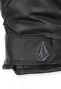 Guanto in pelle nera con superficie testurizzata, caratterizzato da un design cucito e un logo ricamato viola su una toppa.