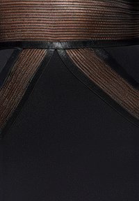 Zwarte jurk met gestructureerde bruine stof en strakke zwarte accenten, met ingewikkelde stiksels en een gestructureerd ontwerp langs de taille.