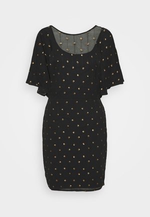 Sort kort kjole med flagrende ærmer og guldfarvede pailletprikker, med bådformet halsudskæring og tætsiddende talje.