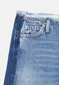 Denim shorts med frynset kant, i en lys blå farge, med en liten frontlomme, metallbeslag og kontrastfarget rød søm.