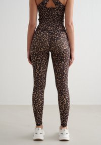 Leggings med leopardmønster i et tettsittende design, med høy midje og rynket detalj bak, laget av et glatt, stretchy stoff.