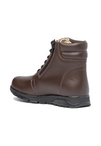 Botín de cuero marrón con cremallera lateral, cuello acolchado, cordones, suela de goma texturizada negra y forro interior beige.
