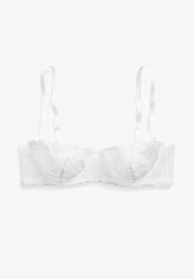 Sostén blanco de encaje con diseño bandeau, que presenta copas lisas y tirantes ajustables, adornado con un patrón de encaje floral y bordes festoneados.