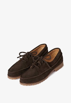 Chaussures à lacets en daim brun foncé avec doublure intérieure couleur noisette et semelles en caoutchouc épaisses, présentées en paire sur fond blanc.