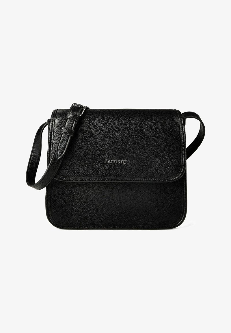 Sac bandoulière en cuir noir texturé avec sangle ajustable et fermeture à rabat, présentant un petit logo Lacoste argenté au centre avant.