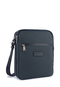 Borsa a tracolla blu navy realizzata in materiale texturizzato, dotata di una tasca frontale con zip, hardware argentato e tracolla regolabile. Design minimalista.