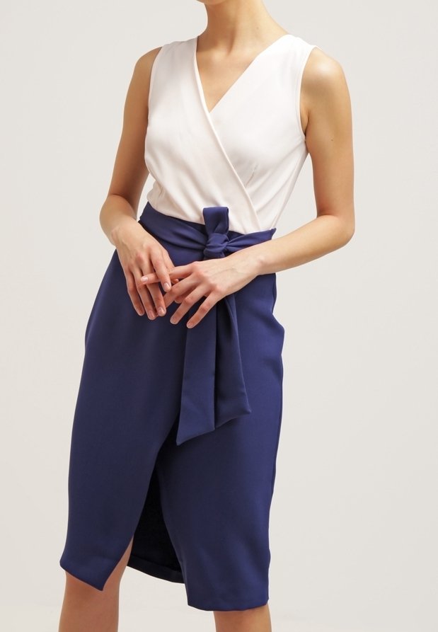 Robe portefeuille bleu marine avec un corsage blanc, dotée d'un détail à la taille nouée, d'une jupe longueur genou et d'une discrète fente à l'avant. Tissu à texture lisse.